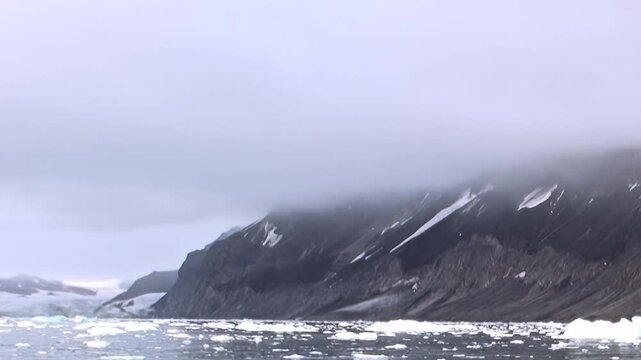 Voyage across the Arctic Ocean, a realm of frozen wonder. Dark mountains stand sentinel, their slopes striped with snow. Shifting ice floats on the water, reflecting the grey, ethereal sky.