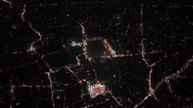 Aerial drone footage of Baba Baidyanath Dham in Deoghar at night, showcasing the illuminated temple complex, glowing city lights, surrounding streets, and the sacred Jyotirlinga pilgrimage site.