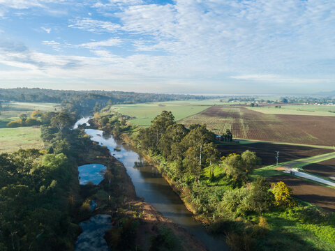 Hunter River aerial landscape with gum trees and paddocks beside waterway