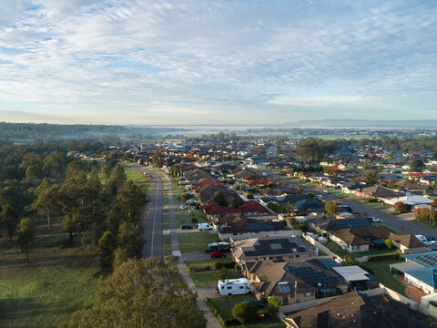 Aerial townscape of residential suburb in country town in Australia on morning with misty horizon