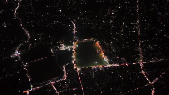 Aerial drone footage of Baba Baidyanath Dham in Deoghar at night, showcasing the illuminated temple complex, glowing city lights, surrounding streets, and the sacred Jyotirlinga pilgrimage site.