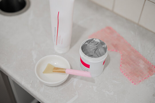 Skincare products and tools laying on a marble countertop for a beauty treatment session