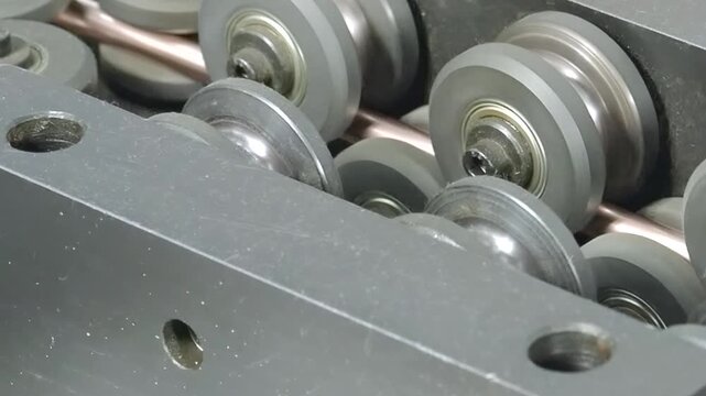 This close-up showcases intricate process of manufacturing copper tube parts for air conditioners in factory setting. Witness slow-motion movement of industrial machine working with precision.