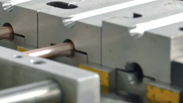 Metal glides through precision machinery, crafting copper tubes for air conditioners. Watch as process unfolds, showcasing intricate movements and beauty industrial design in captivating slow motion.