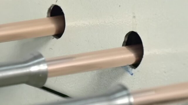 Observe the intricate process of copper tube part manufacturing for industrial air conditioners. The slow motion highlights the delicate movements of the machines as they create essential components.