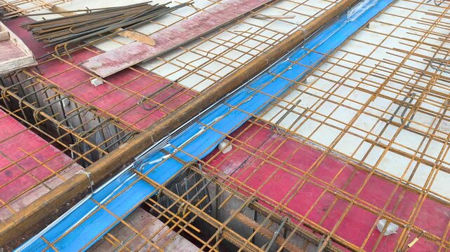 A blue rubber waterstop is installed along a concrete slab construction joint. It acts as a barrier to prevent water ingress through roof slab joints. The fitting ensures structural waterproofing.