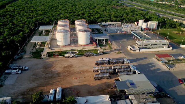 Merida, Yucatan, Mexico - 09 July 2026: Aerial view of petrochemical factory with storage tanks and tanker trucks in an industrial facility.