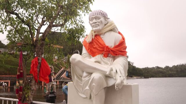Statue of Sai Baba at Ganga Talao Hindu temple complex in Grand Basin, Mauritius. A sacred spiritual site with traditional offerings and architecture