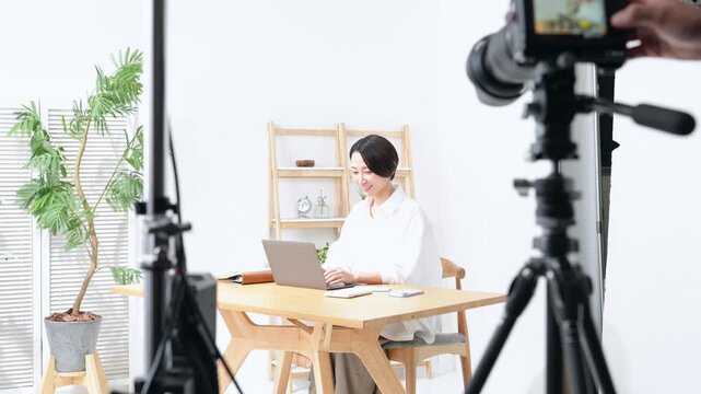 ハウススタジオでモデル撮影する風景。収録、カメラ、ビデオ、CM、中継、広告、ライフスタイル、女性