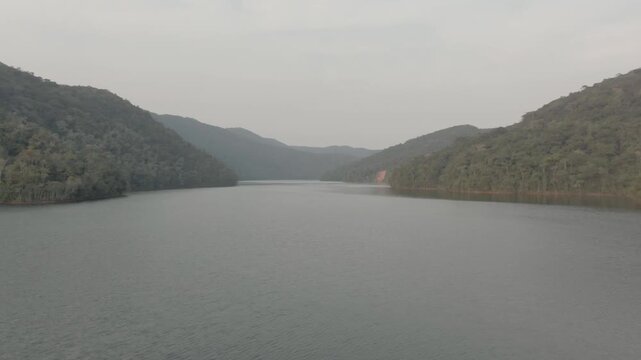 Aerial flying over calm waters of Juquia River on cloudy day, Brazil