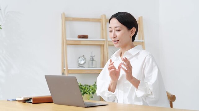 ノートPCに向かって話すミドル女性。web会議、ビデオ通話、レッスン、ウェビナー、配信、セミナー