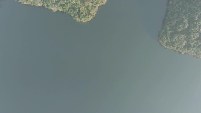 Aerial birdseye flying over river cutting through Atlantic Forest, Brazil