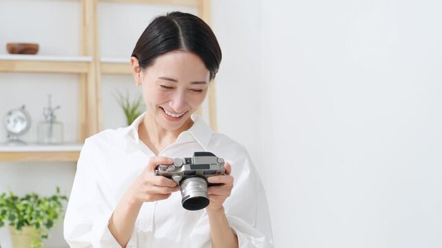 デジタルカメラを使う女性。写真、動画、編集、撮影、カメラマン、カメラ女子、現像、スタジオ、趣味、副業