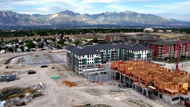 Taylorsville, Utah - 05 July 2026: Aerial view of new apartment buildings under construction with wooden framing and mountain backdrop in Taylorsville, Utah, United States.