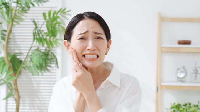 奥歯が痛むミドル女性。虫歯、親知らず、デンタルケア、歯科医、痛い、ストレス、困る、悩み、治療、歯医者