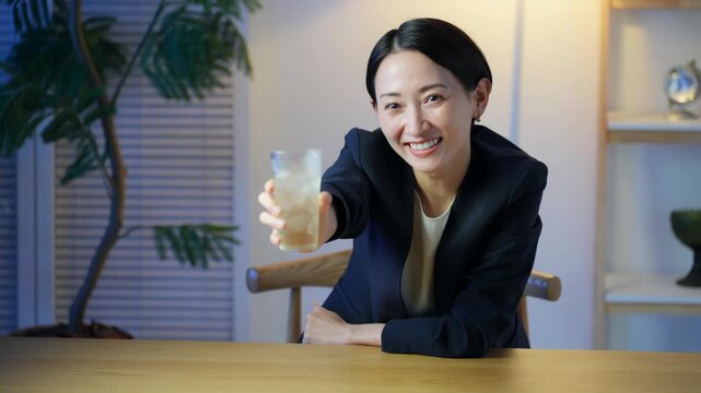 コップを持って乾杯するミドル女性。お酒、飲み会、居酒屋、ハイボール、笑顔、バー、カクテル、サワー