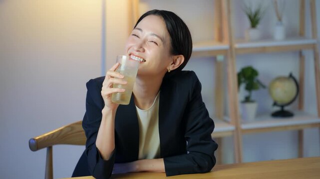 暗い部屋でお酒を飲む女性。ハイボール、ウイスキー、カクテル、飲み会、居酒屋、バー、スナック、宅飲み