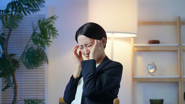 頭が痛むミドル女性。頭痛、片頭痛、悩み、ストレス、不安、心配、過労、疲労、会社員、疑問、不満、残業