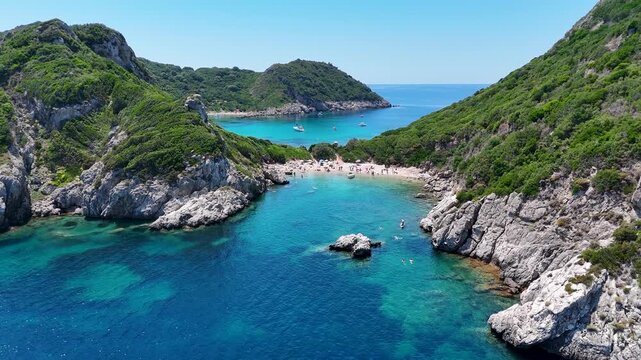 Kerkira, Corfu, Greece - 29 June 2026: Aerial view of Porto Timoni beach with turquoise waters, rocky cliffs, and lush green vegetation.