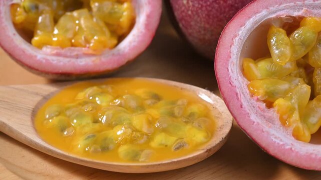Ripe Passion Fruit Pulp with Seeds in Wooden Spoon