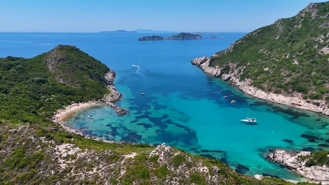 Kerkira, Corfu, Greece - 29 June 2026: Aerial view of Porto Timoni beach with turquoise waters, rocky cliffs, lush greenery, and boats in the Ionian Sea.