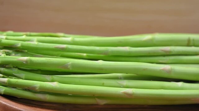 Fresh Green Asparagus on Wooden Plate