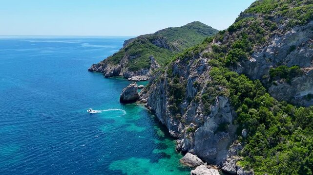 Kerkira, Corfu, Greece - 29 June 2026: Aerial view of Porto Timoni beach with rocky cliffs, lush green vegetation, and turquoise water.
