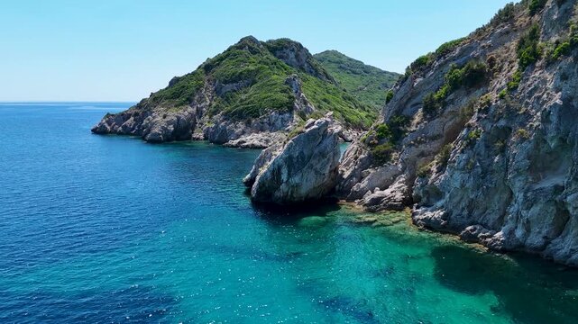 Kerkira, Corfu, Greece - 29 June 2026: Aerial view of Porto Timoni beach with turquoise waters, rocky cliffs, and lush green vegetation on the coastline.