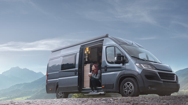 Frau mit Camper Van in den Bergen 