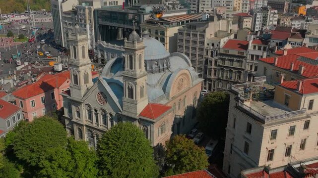 Beyoglu, Istanbul, Turkiye - 30 June 2026: Aerial view of Aya Triada Greek Orthodox Church surrounded by historic urban buildings and rooftops.