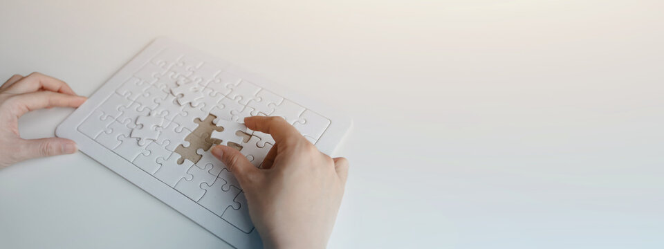 Business professional arranging puzzle pieces on a digital interface, representing problem solving, business strategy, planning, teamwork, innovation, and decision making.