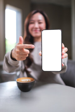 Vertical mockup image of a woman holding and pointing finger at a mobile phone with blank white screen