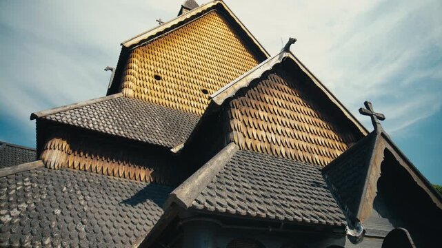 Close-up view of the intricate wooden architecture of Heddal Stave Church in Telemark, Norway. The low-angle perspective highlights the medieval roof construction and carved dragon heads