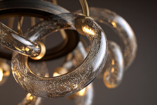 Modern luxury artistic ceiling chandelier lamp close up with twisted transparent glass tubes filled with glowing glitter gold dust particles, elegant interior lighting decoration design element.