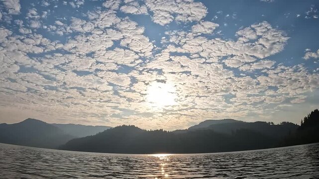 4K smooth stabilized action camera footage while kayaking on Yale Lake, Washington, USA with gentle waves, surrounding forested mountains and morning sunlight reflecting on the water during summer