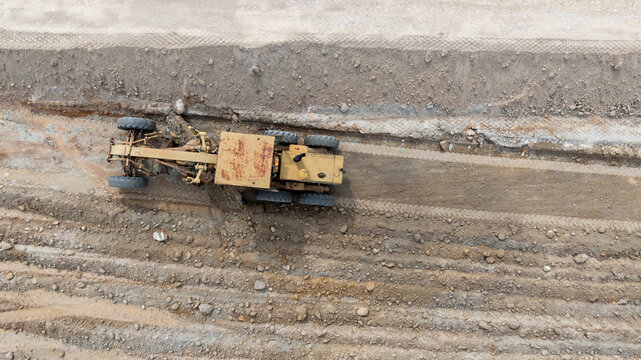 Aerial view motor grader civil at construction site, Motor grader work on construction site, Road grader on road construction site machine work on the construction of new road.
