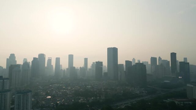 Modern City Skyscrapers Covered in Heavy Smog During Hazy Sun Up