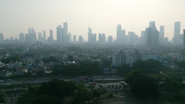 Aerial View of Highway Traffic and Hazy City Skyline Covered in Smog
