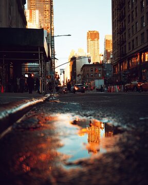 Urban Reflection - Cityscape Mirrored in a Puddle on a Street.