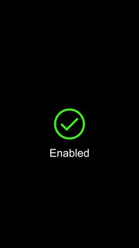 Minimalist green checkmark animation showing enabled status on black background, success verified confirmation