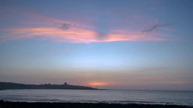 A breathtaking romantic sunset casting vibrant pink and blue colors over the calm sea and coastline in Shimen, New Taipei City, Taiwan.