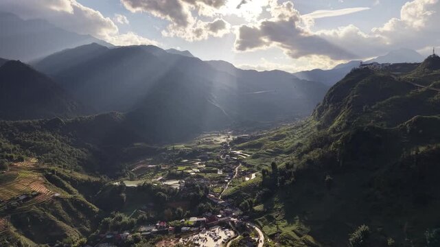 Aerial View Approaching Mountain Valley with Sunbeams and Terraced Rice Fields in Sapa