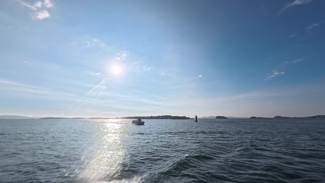 Marine leisure and boating background footage featuring vessel navigating calm sea with sun path