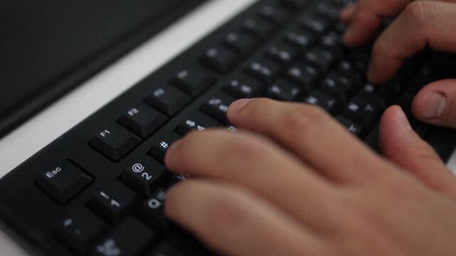 A close-up of a person's hands typing on a dark mechanical keyboard with Korean and English key labels in a workspace.