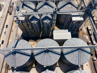 Industrial storage facility with grain silos and processing equipment located near a railway during daytime © DSMT