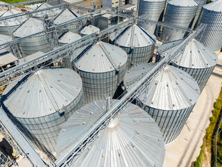Storage silos are seen from above at an agricultural facility during a sunny day displaying their metal structure and layout © DSMT
