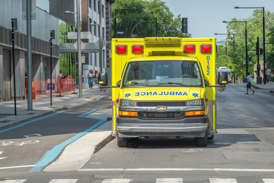 Montreal, Quebec, Canada. July 30, 2026. Front view of a yellow paramedic ambulance vehicle parked on a city street on a sunny day.