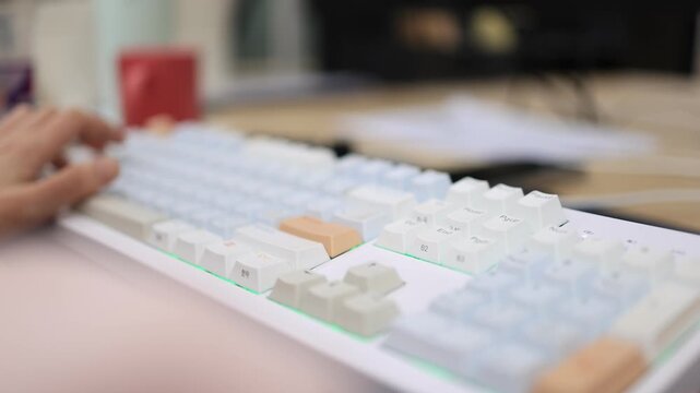 A close-up of a white mechanical keyboard with colorful accent keycaps and no hands visible in a bright clean workspace.