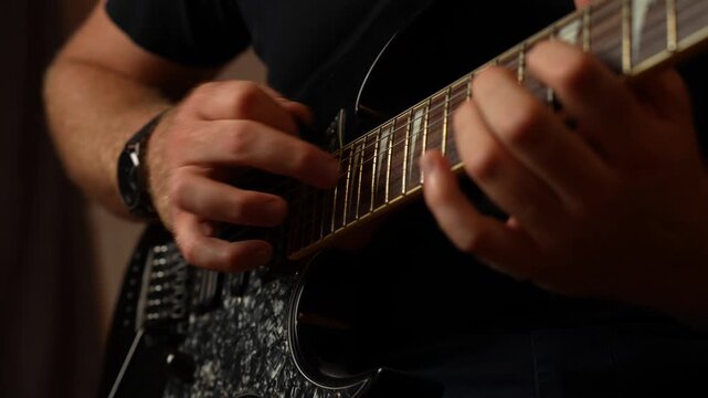 Young guy with ginger beard playing electrical guitar. Strumming and tapping and string picking.