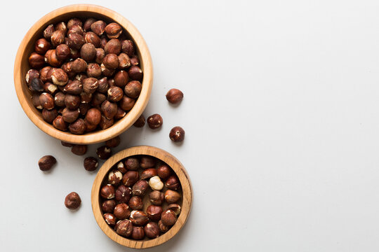 Wooden bowl full of hazelnuts on table background. Healthy eating concept. Super foods